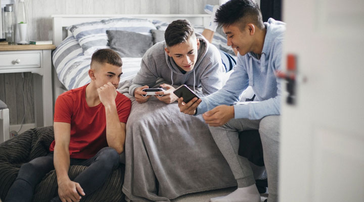 اهمیت آموزش مسائل جنسی به کودکان + راهنمای آموزش در سنین مختلف 5 آموزش مسائل جنسی به نوجوانان ـ چند نوجوان در حال صحبت و کندوکاو در اینترنت